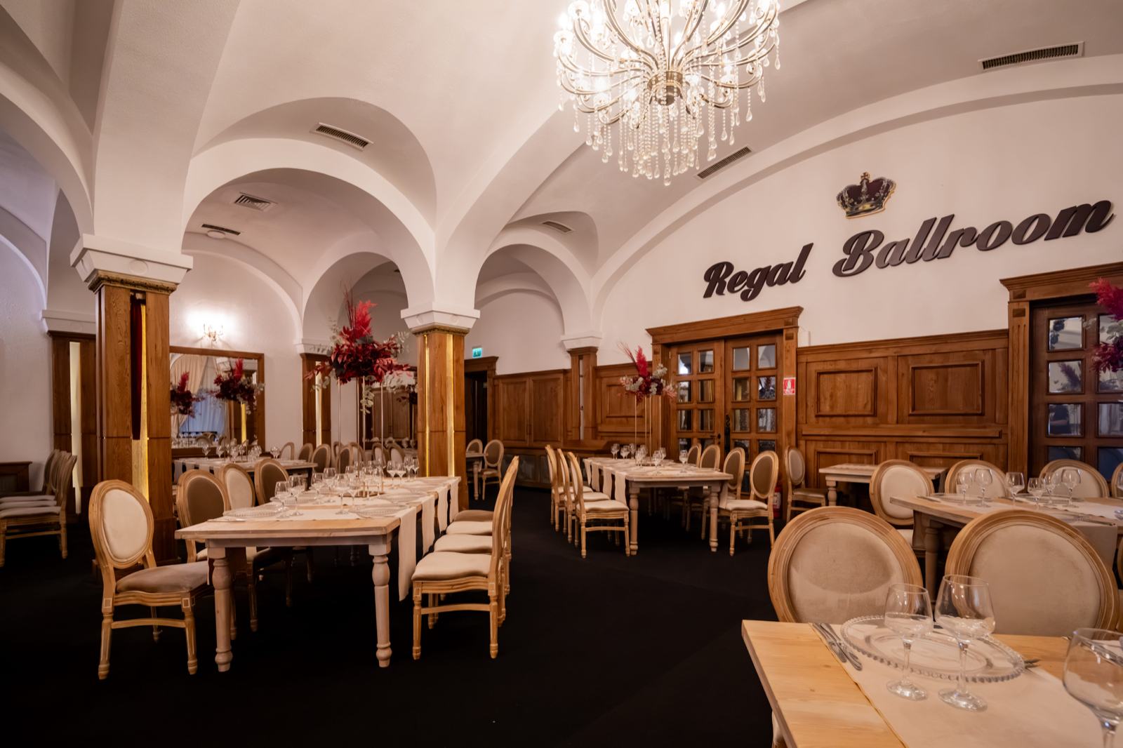 Sală cu bolți albe și candelabru, cu numele Regal Ballroom pe perete