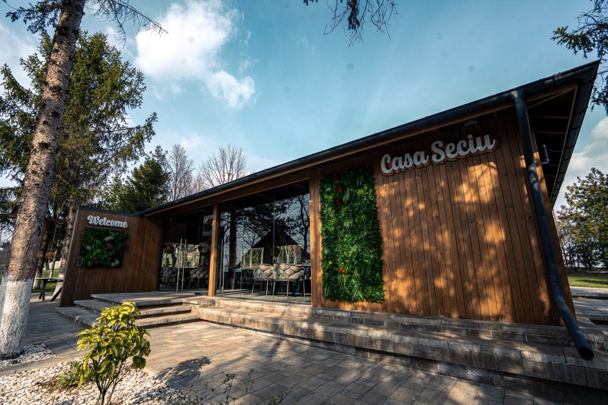 Clădirea terasei văzută din grădină, cu numele Casa Seciu pe lemn