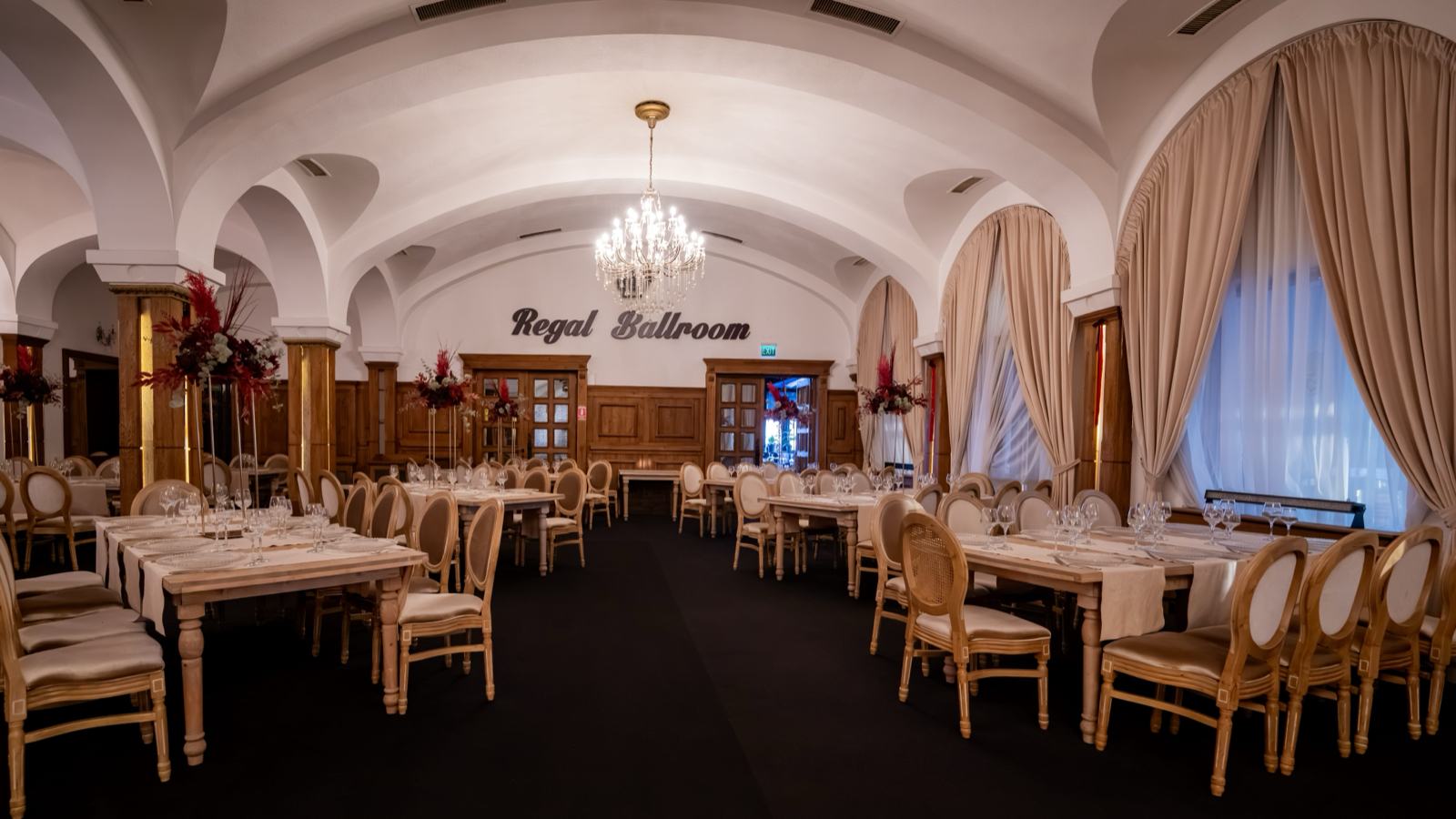 Sală cu bolți albe și candelabru, cu numele Regal Ballroom pe perete